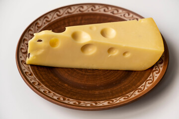 a large piece of cheese lies on a ceramic plate