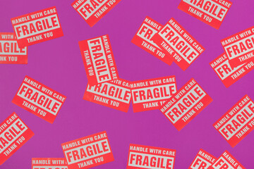 Valentines day creative pattern made with Fragile Warning Sticker Labels on bright purple...