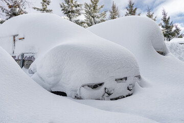 car covered with snow after a heavy snow storm.Vehicles are covered with snow during a heavy snowfall.