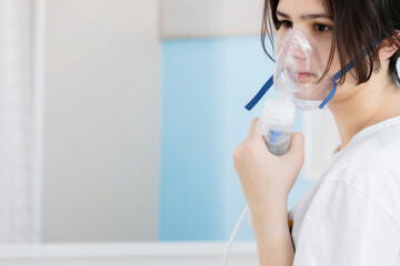 A nebulizer mask on the girl's face. The concept of treatment of respiratory diseases, chronic bronchitis, recovery.