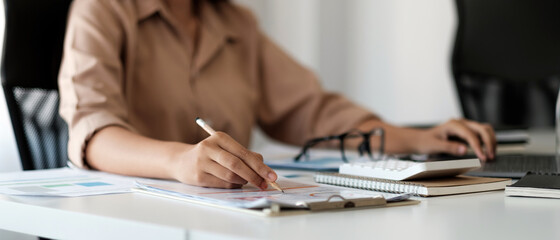 Close up business woman using calculator and working to calculate about finance accounting at...