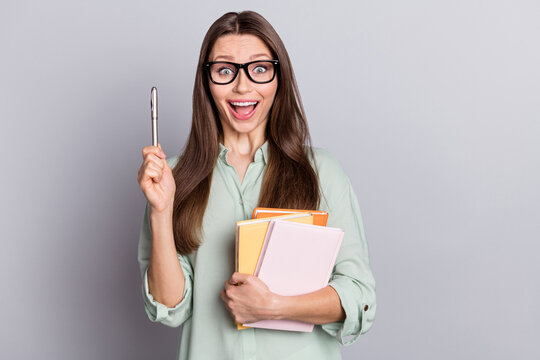 Photo of hooray brunette student lady index up hold books wear eyewear blue blouse isolated on grey color background