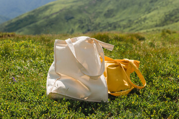 Canvas tote bags on green grass on the edge of the hill in the park. Eco Nature Friendly Style....