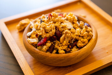 wooden bowl with granola on the black table. close up breakfast