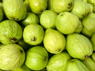 Close-up photo of guavas in market. Fruits background. Texture green guava. 