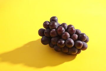 Red grapes isolated in yellow background
