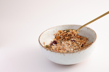 granola with milk with spoon isolated in white background