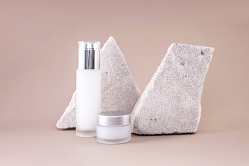 glass containers for natural cosmetics and stones on a brown background
