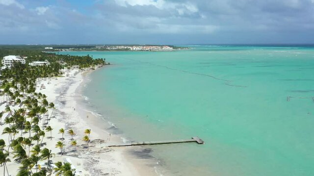 Juanillo beach with palm trees, white sand and turquoise caribbean sea water. Cap Cana is a tourist area in Dominican Republic. Aerial view