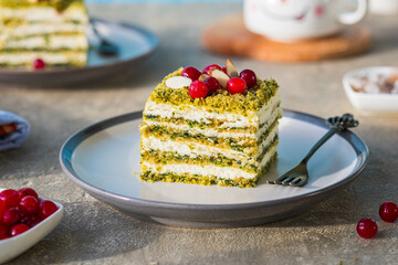 Dessert, sliced spinach cake with sour cream or cream cheese cream on a ceramic plate on a gray concrete background. Dessert recipes.