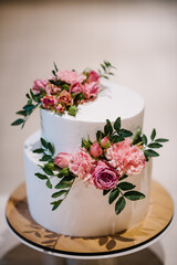 White wedding cake with pink flowers for wedding banquet. Delicious wedding reception. Copy space. Celebration party concept. Trendy Cake.