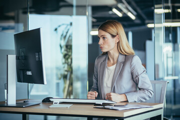 Angry and angry businesswoman looks at the computer screen, dissatisfied with the results of statistical tests, works in the office