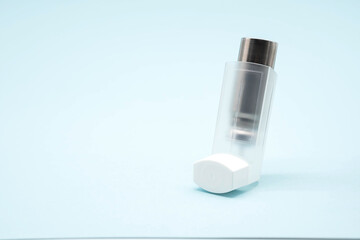 Asthma inhaler on blue background, copy space. Aerosol for inhalation, treatment of bronchial asthma, COPD. Pharmaceutical product for treat lung inflammation and prevent asthma attack. 