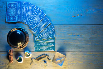 Tarot cards and crystal ball on the wooden table of the fortune teller concept. Top view.
