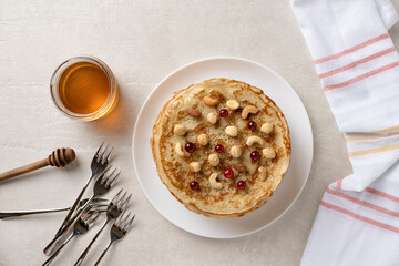 Thin pancakes crepes with honey on a white plate. Light marble background. top view.