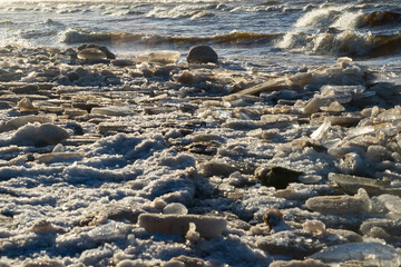 Fototapeta na wymiar frozen sea side beach panorama in winter with lots of ice and snow in late evening