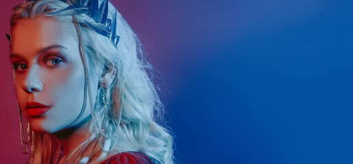 Queen in a silver crown in neon in blue and red. Theme party, place for text. Blonde mother of dragons. Evening make-up, jewelry
