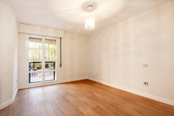 Empty room with double window and bay window with cherry wood flooring and white walls