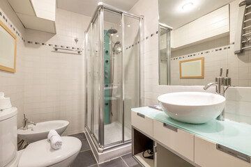 Modern bathroom with glass countertop and hydromassage shower in short-term rental apartment