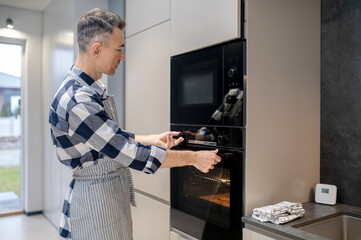 Profile of man touching toggle switch and oven door
