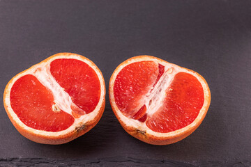 Close up view of ripe cut into two  grapefruit isolated on cutting board.