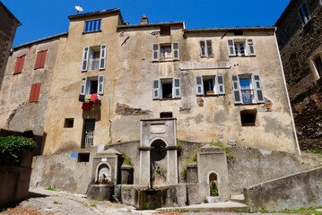 Traditional stone houses and fountain in Stazzona, a dreamy mountain village nestled in the mountains of Castagniccia. Corsica, France.