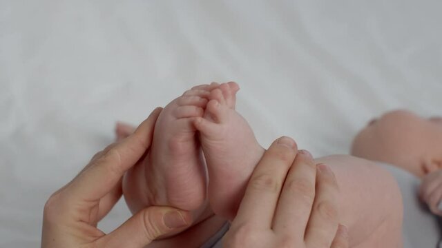 Child Care. Closeup Of Loving Mother Playing With Newborn Baby's Tiny Feet