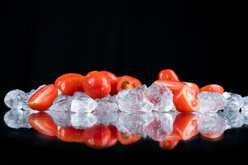 tomatoes on a black background with ice cubes and crushed ice