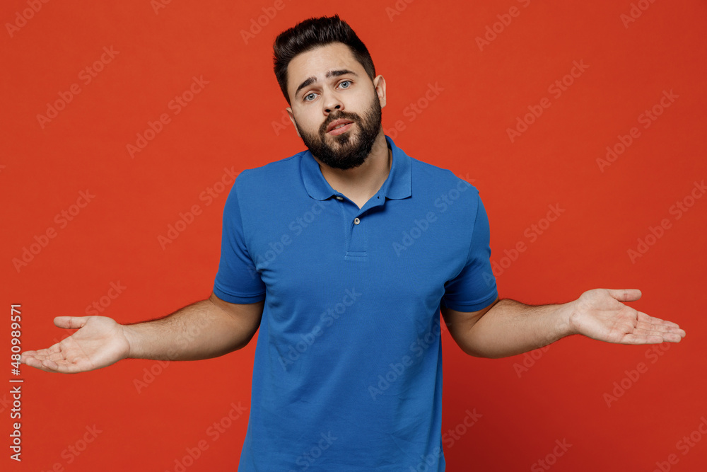 Poster Young mistaken confused unhappy caucasian man 20s in basic blue t-shirt look camera shrugging shoulders looking puzzled, have no idea spread hands isolated on plain orange background studio portrait