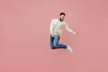 Fototapeta na wymiar Full body young expressive singer happy caucasian man 20s in trendy jacket shirt jump high play guitar gesture isolated on plain pastel light pink background studio portrait. People lifestyle concept.