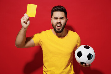 Irritated young bearded man football trainer in t-shirt hold soccer ball hold soccer ball show...
