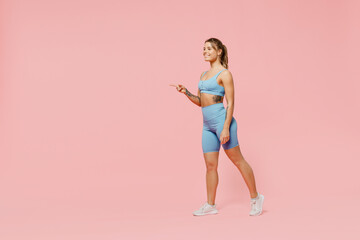 Full body fun young strong sporty fitness trainer woman wear blue tracksuit spend time in home gym...