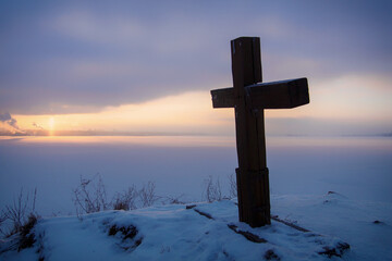wooden Orthodox cross on the background of the Kama river in winter