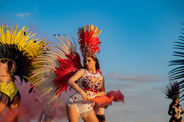 Amazing attractive samba girl holding smoke bomb on samba outdoors party 