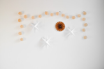 Home interior design with paper stars, knit balls on the wall, handmade accessories. Retro cozy home decor. scandi-boho style.
