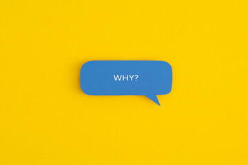 Paper speech bubble with the word "Why" on a yellow background. Top view with copy space. Flat lay.