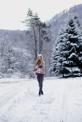 The model poses in winter clothes on the road. snowy winter