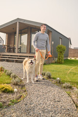 Man walking with dog near country house