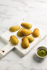 French madeleine cookies with matcha tea on the board. Menu concept. 