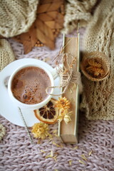 Still life with coffee with dried flowers on a knitted fabric
