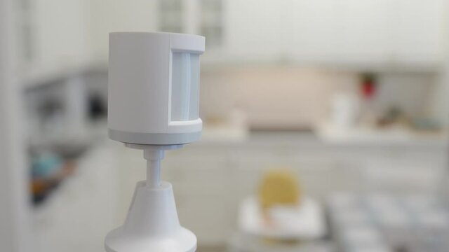 Smart home wireless motion sensor installed in the living room detects movement, motion detector used to detect burglar intrusion. High quality 4k footage