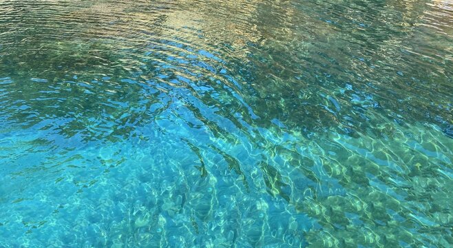 Sea water ripples surface background. Beautiful turquoise blue sea watercolor. Clear transparent ocean water.