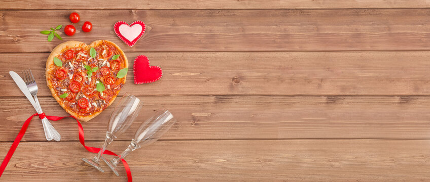 Valentine's Day banner with pizza heart and wine glasses on a dark wooden background with copy space