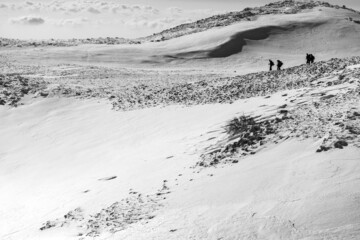 hikers walk on a snowy plateau in the Matese mountains. Monte Mutria, Matese National Park, Campania and Molise, Italy
