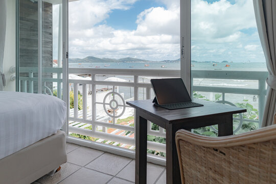 Tablet on the table at the balcony of hotel room with sea view.