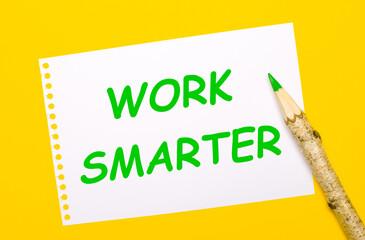 On a bright yellow background, a large wooden pencil and a white sheet of paper with the text WORK SMARTER