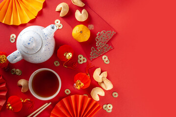 Chinese new year background. Red and golden yellow flatlay with traditional Chinese new year decor, envelopes with wishes, gold coins, fans, Chinese lanterns, oranges and tea