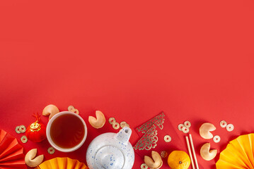 Chinese new year background. Red and golden yellow flatlay with traditional Chinese new year decor, envelopes with wishes, gold coins, fans, Chinese lanterns, oranges and tea