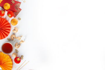 Chinese new year background. Red and golden yellow flatlay with traditional Chinese new year decor, envelopes with wishes, gold coins, fans, Chinese lanterns, oranges and tea