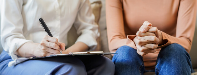 Psychology, depression. Sad, suffering asian young woman consulting with psychologist, psychiatrist while patient counseling mental with doctor woman taking notes at clinic. Encouraging, therapy.